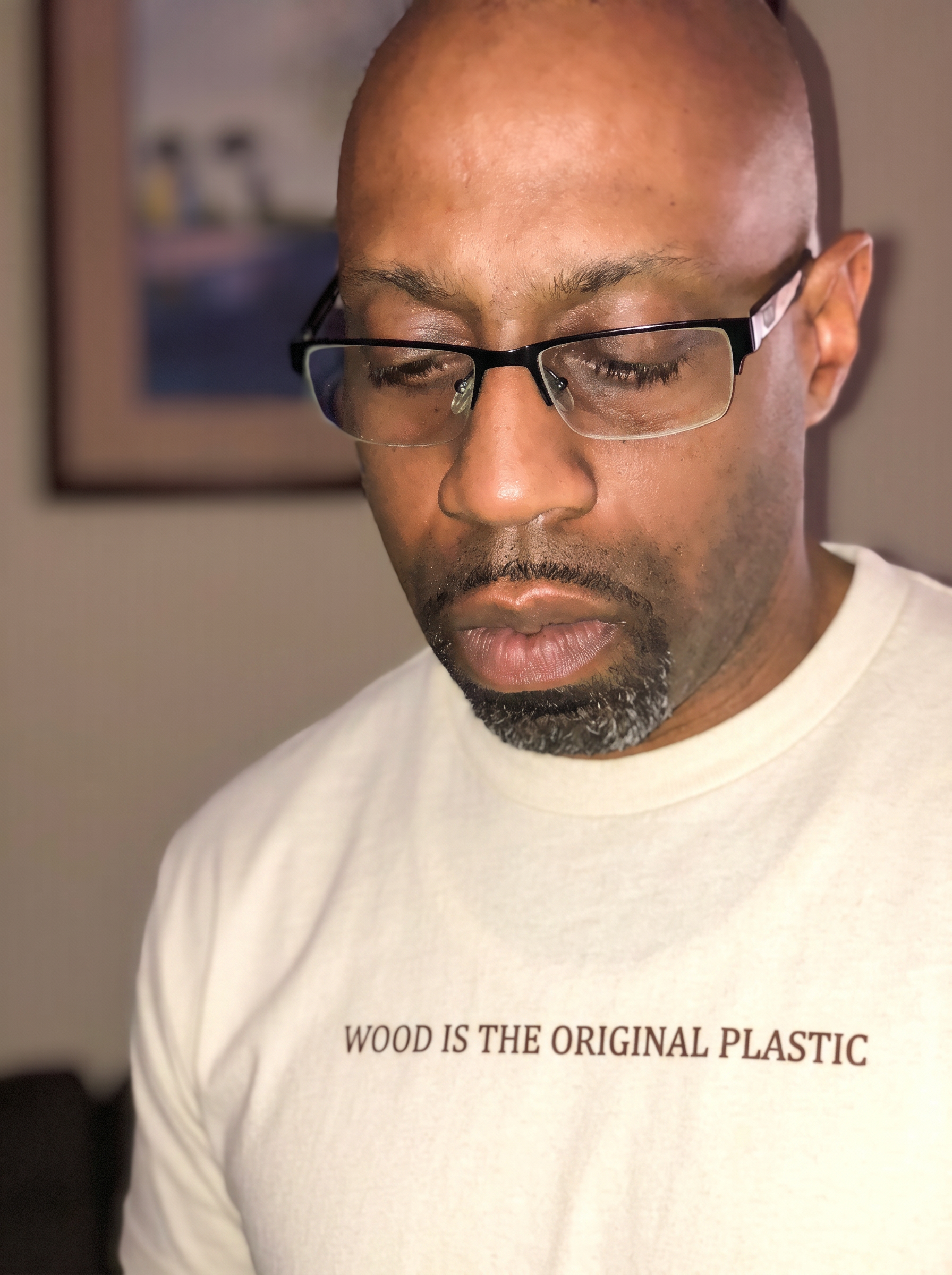 Dominic wearing a cream heavyweight t-shirt printed with WOOD IS THE ORIGINAL PLASTIC