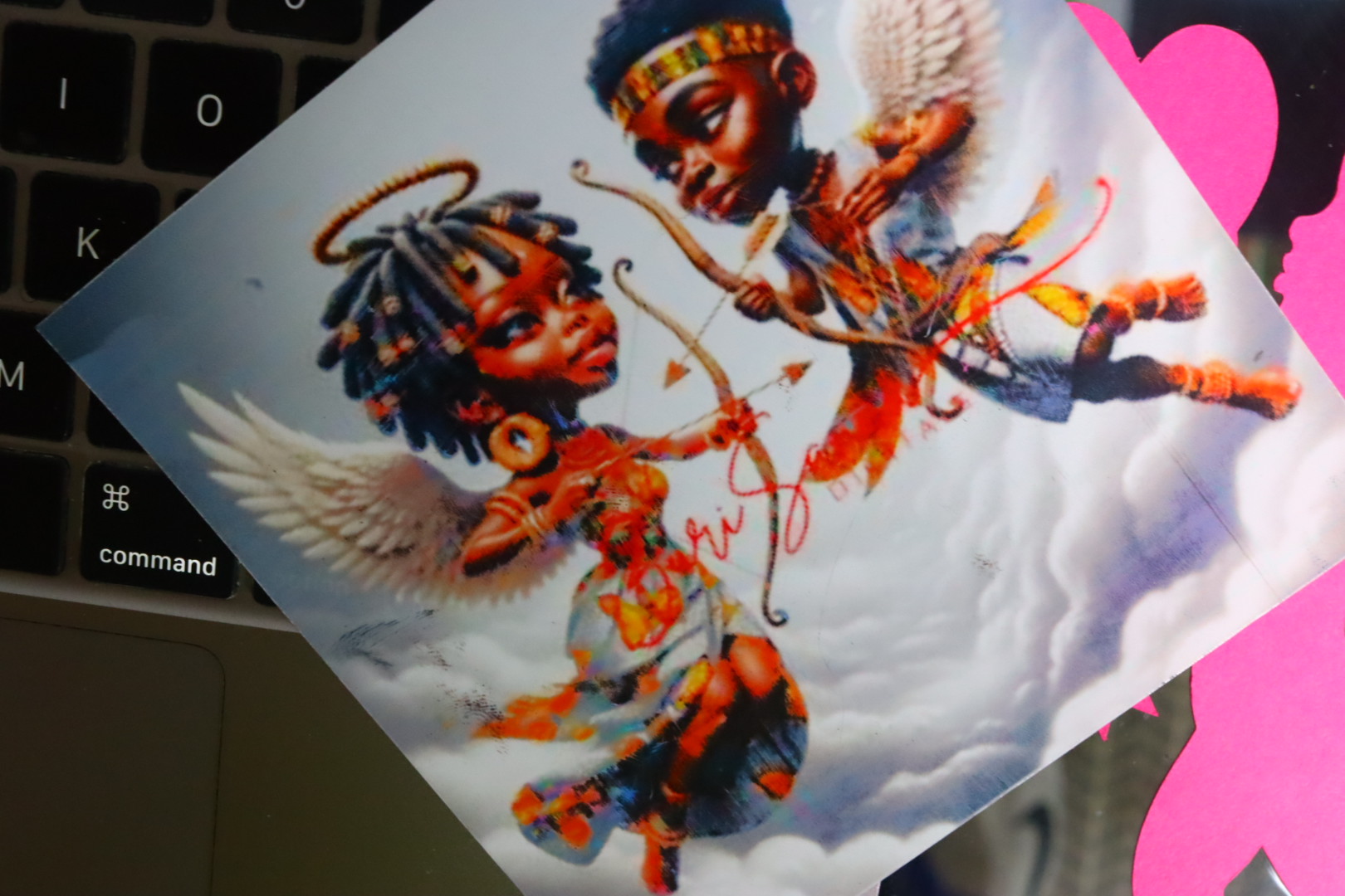 Colorful transfer print of two winged cherub characters with bows and arrows