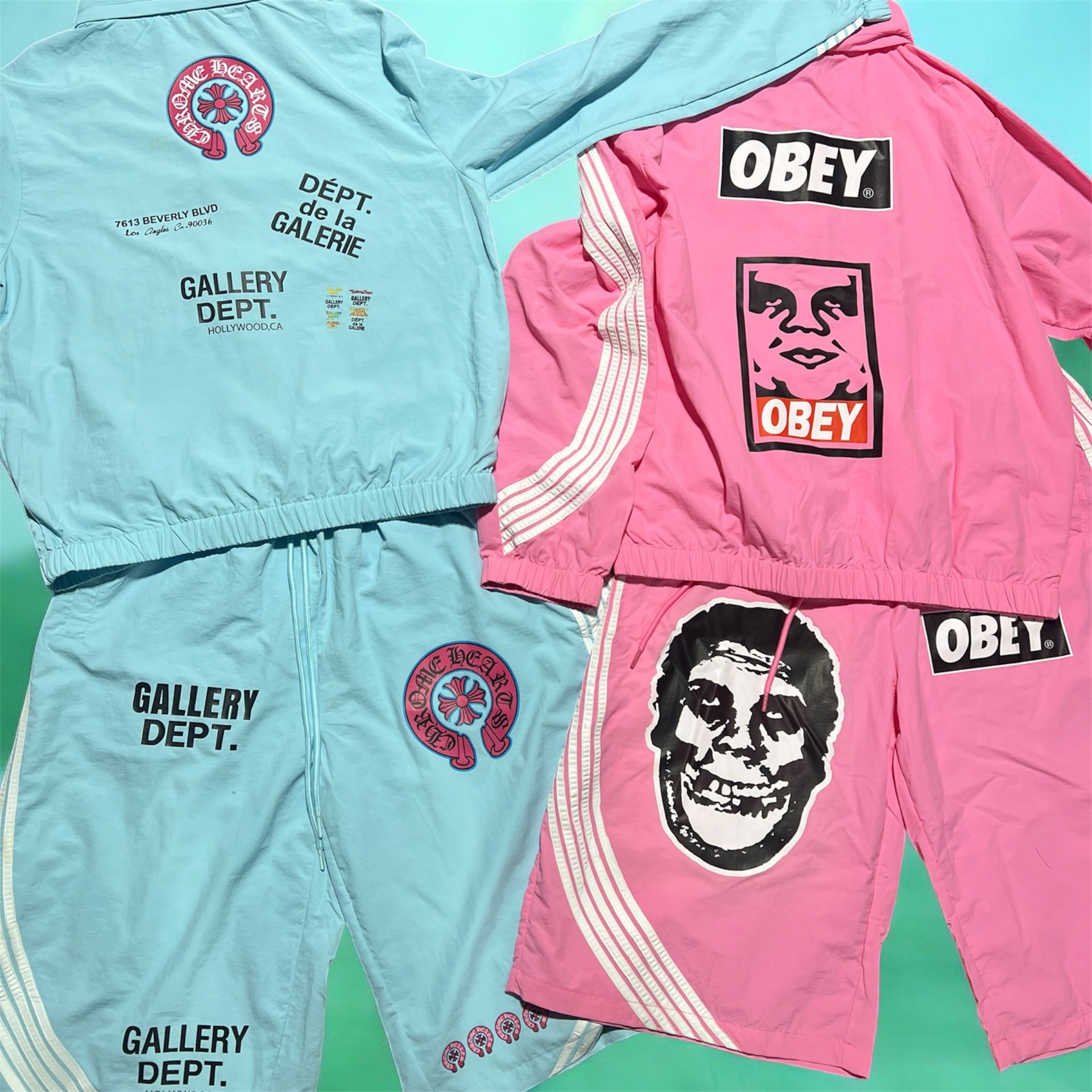 Two printed tracksuit sets in powder blue and pink laid flat side by side