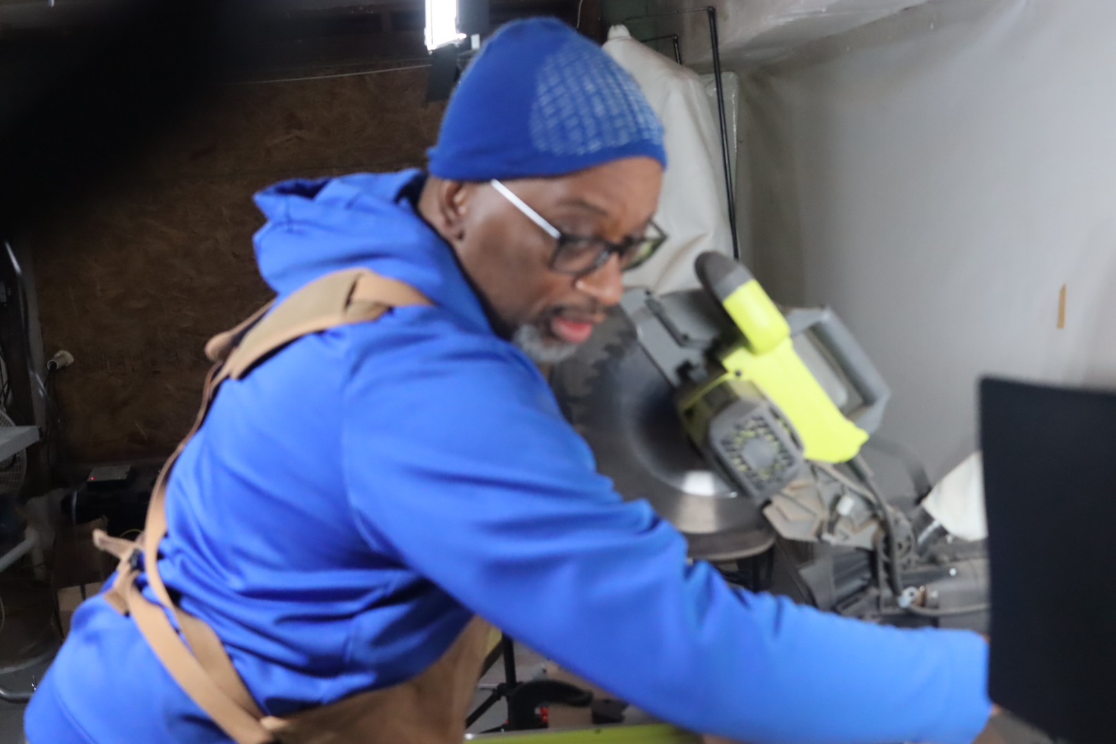 Carl making a cut at the miter saw in the workshop