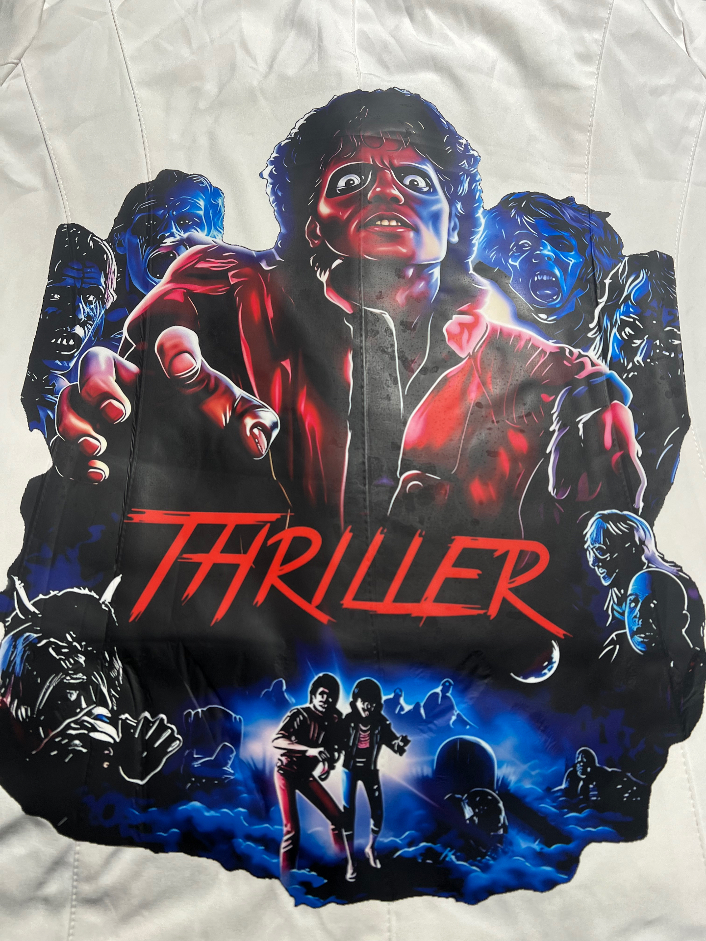 White jacket back panel printed with a red and blue 1980s horror-musical graphic