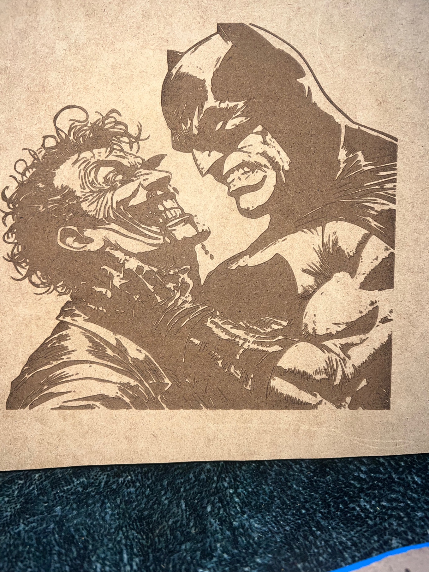 Laser-engraved panel of two comic characters face to face, burned into natural board